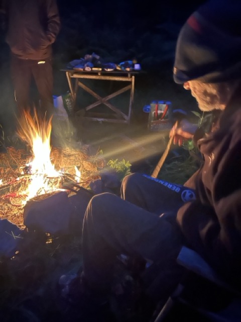 Olof sitter vid elden en mörk kväll – en stilla stund på gården